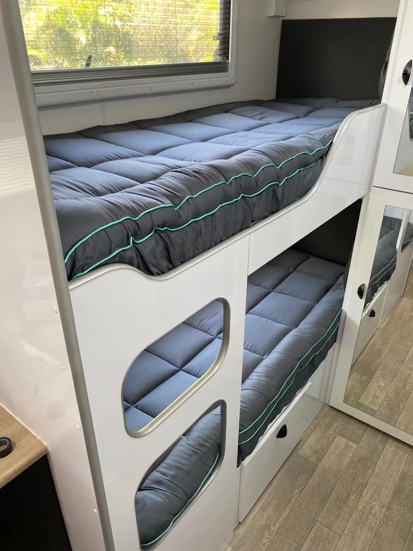 Caravan bunk beds dressed in slate-grey toppers with teal piping
